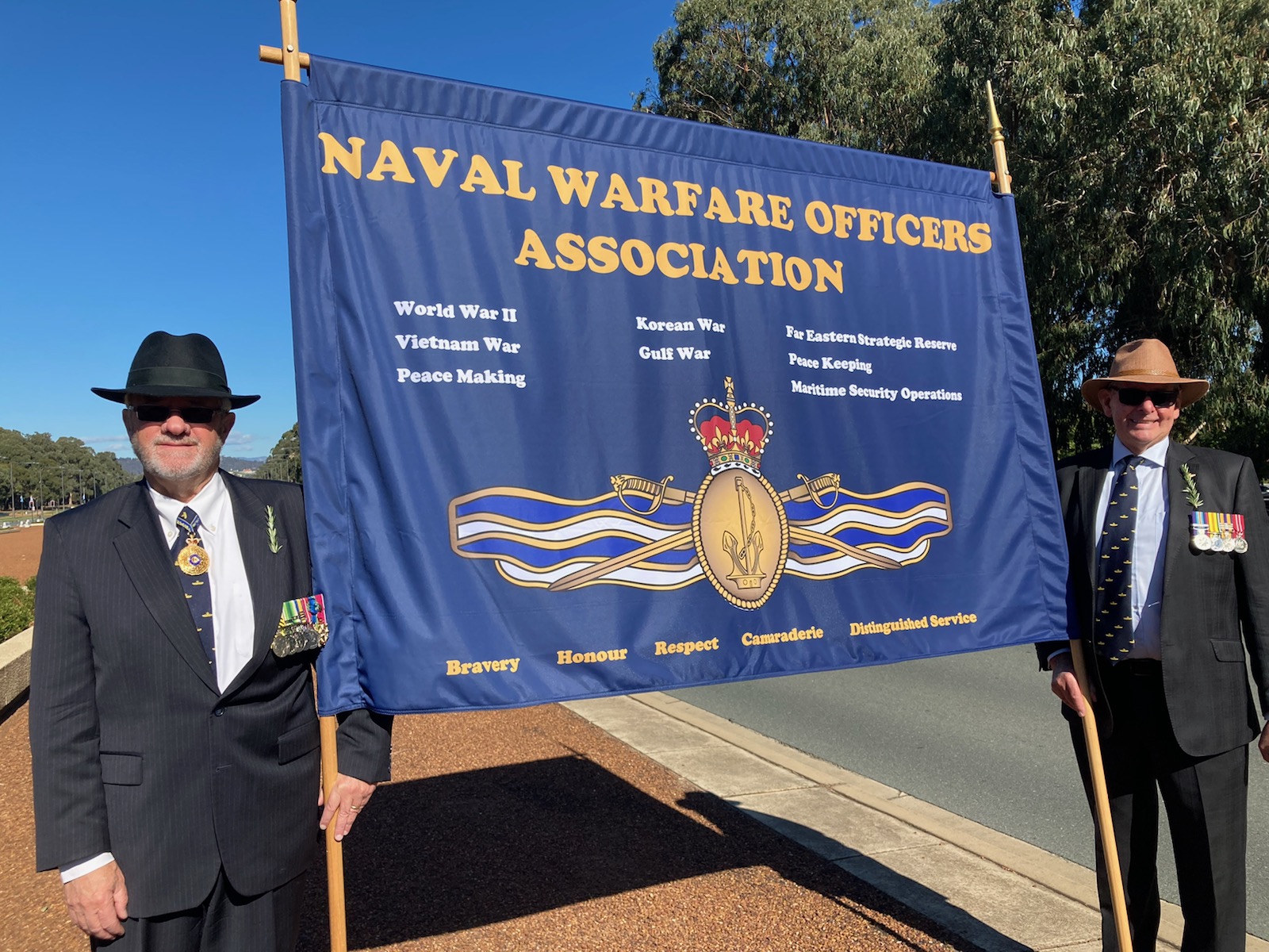 Raydon Gates John 
 Jacobi display the new NWOA banner Canberra Anzac Day March 2021